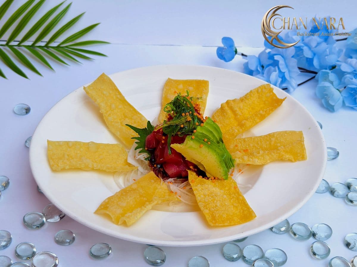 Tuna Poke with diced tuna, poke sauce, seaweed salad, sliced avocado, and crispy wonton chips