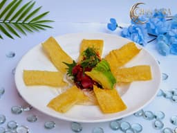 Tuna Poke with diced tuna, poke sauce, seaweed salad, sliced avocado, and crispy wonton chips