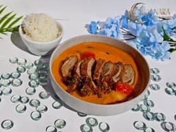 Roasted Duck Curry with roasted duck, coconut curry broth, lychees, pineapple, cherry tomatoes, and Thai basil