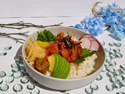 Salmon Poke Bowl with giant cuts of salmon, poke sauce, rice, masago, cucumber, seaweed salads, red radish, and avocado